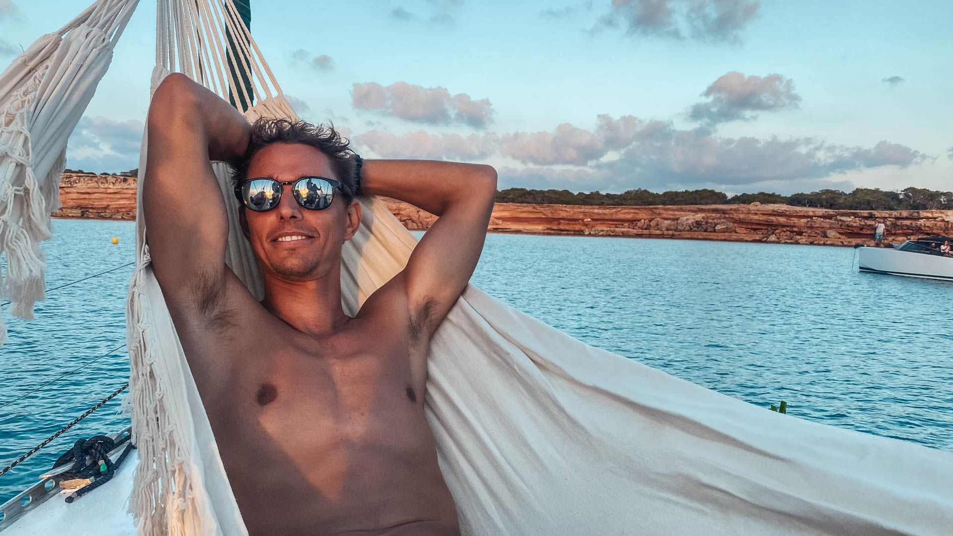 Relaxed moment in a hammock on board at sunset