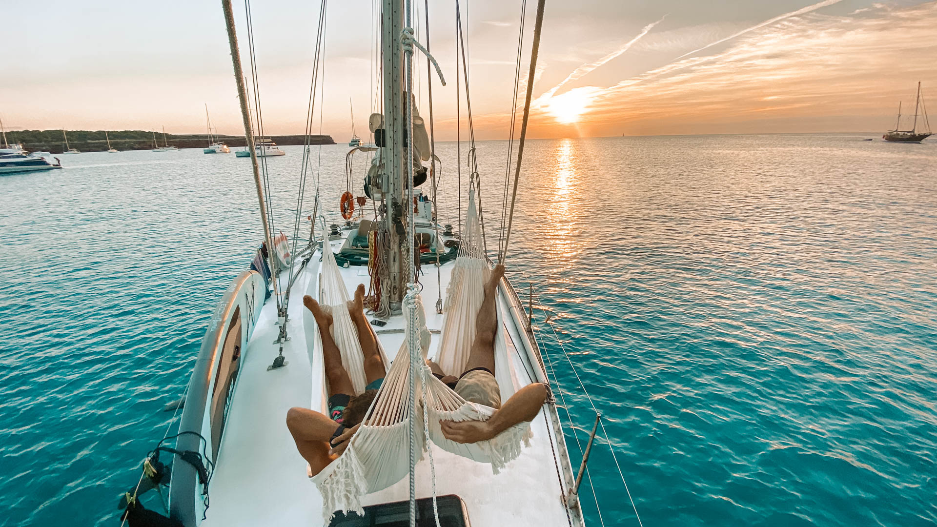 Guests relaxing in hammocks during sunset on board